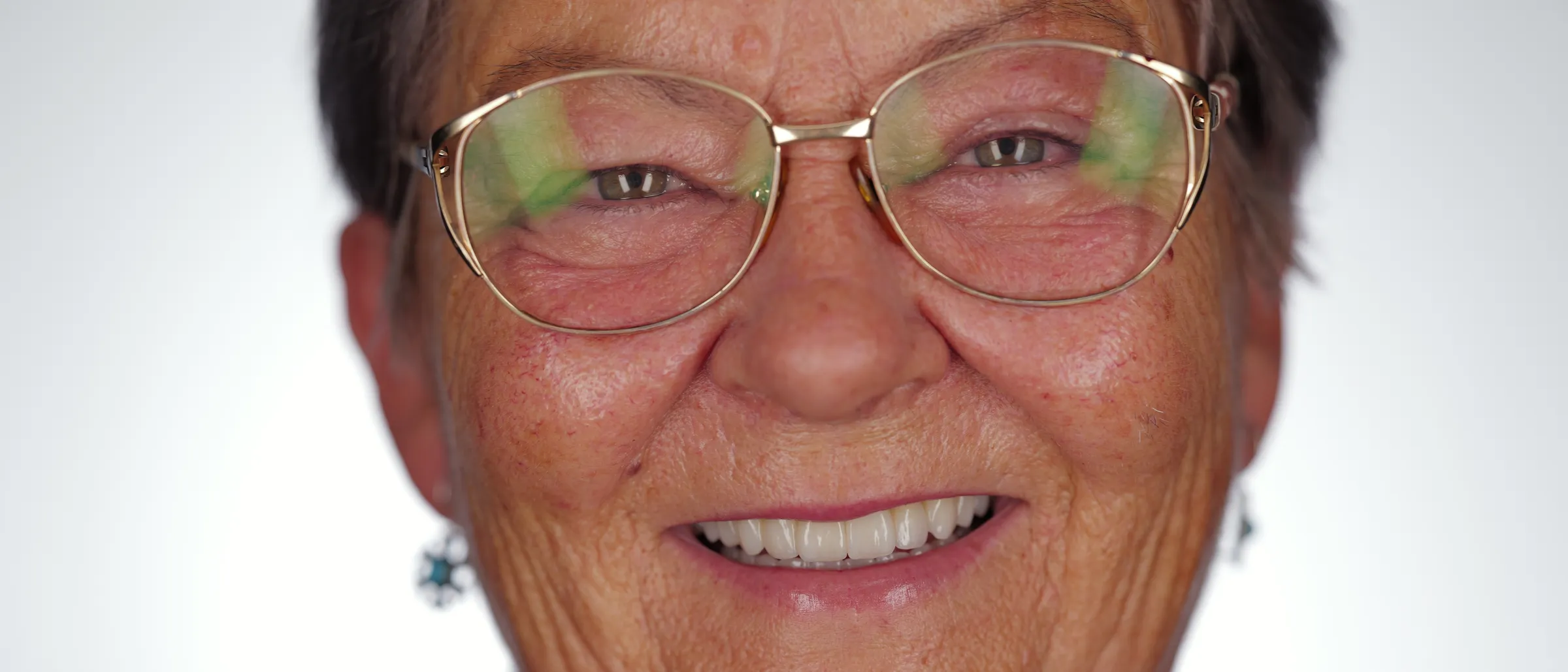 A smiling older woman with glasses