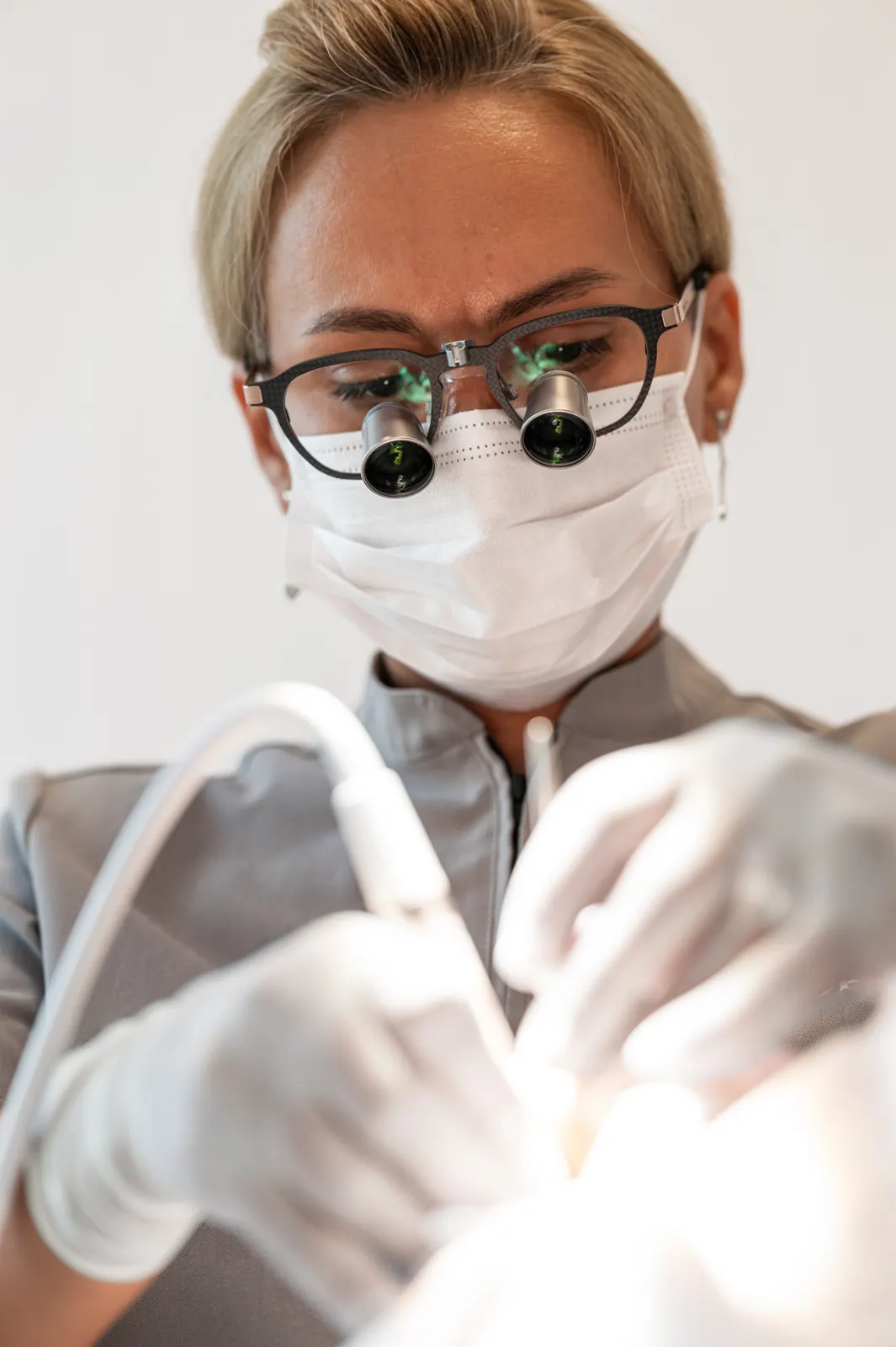 Hygienist with magnifying loupes working carefully on a patient's teeth