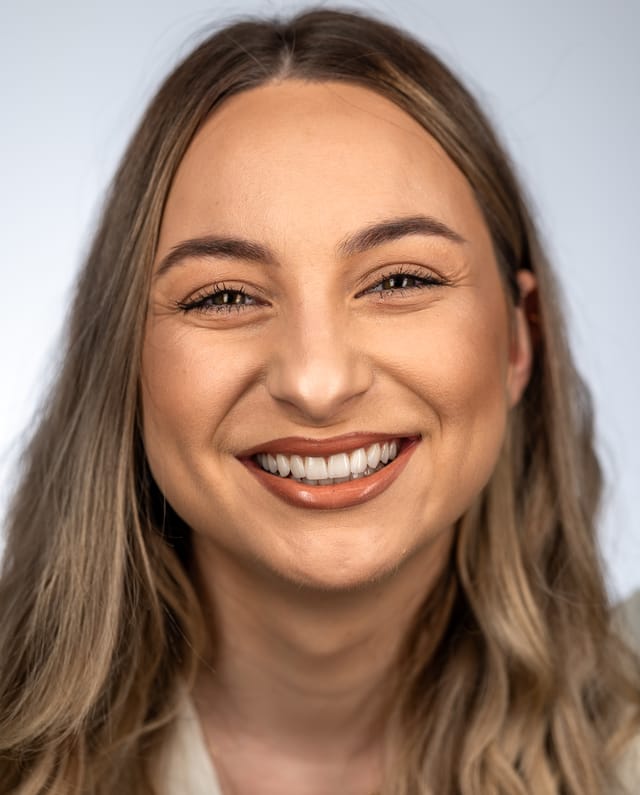 Post-treatment smile showing refined tooth length and harmonious gingival levels.